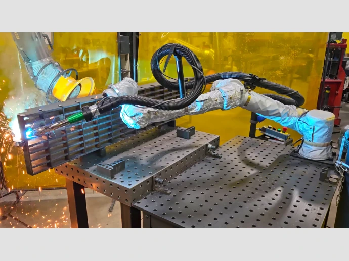 A bar grating being welded with a robotic welder