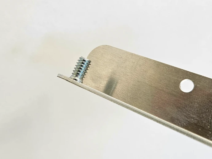 A PEM stud pressed into a part from a hardware insertion machine